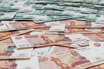 Scattered five thousandth Russian bills with thousandths in the background