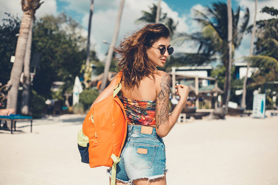 Beautiful young girl in a yellow raincoat riding an electric scooter, hoverboard, in orange sunglasses with long hair, street-style, city, smiles and pleasure, for fan, hipster, driver, emotional