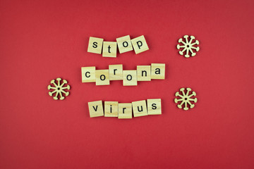The inscription Stop Coronavirus of wooden cubes on a red background.