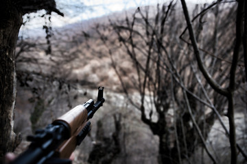Shooter aiming target with assault rifle weapon. dangerous bandit holding gun in hand. Shooting...