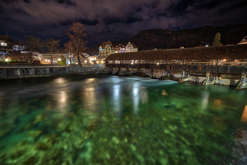 Naklejka premium Flowing water under bridge during overcast night