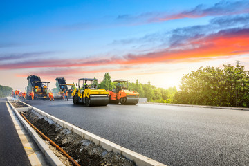 Construction site is laying new asphalt road pavement,road construction workers and road...