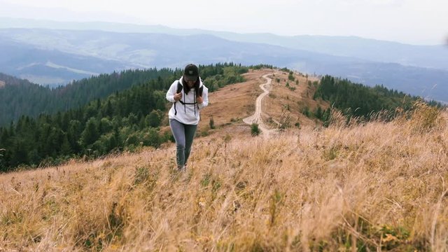 woman with backpack hiking by mountains beautiful panoramic view