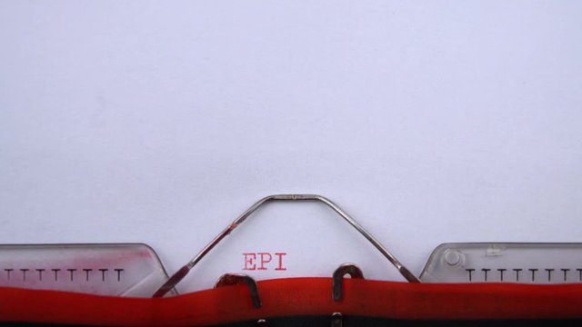 Epilogue - word printed on an old typewriter in red letters, close up. vintage inscription