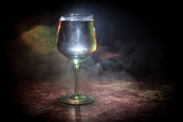 Goblet of white wine on wooden table on wooden wall background