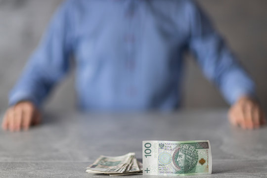 Plik polkich pieniędzy i szef siedzący naprzeciwko, czas wypłaty