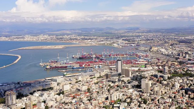 Aerial footage of Haifa, Israel, showing houses downtown area with Haifa bay and port in the background.