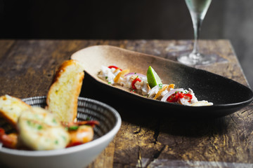 Lubina Ceviche with lime juice, shallots, a wedge of lime and fried garlic