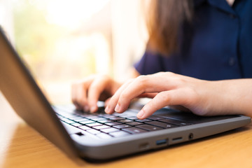 Young woman’s hands typing on her laptop computer’s keyboard
