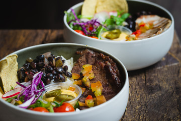 Protein Bowl of grilled Striploin, pilaf rice, beans, guacamole, homemade spiced cheese sauce, jalapenos & corn chips
