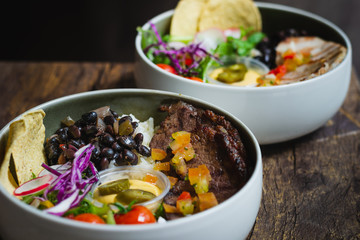 Protein Bowl of grilled Striploin, pilaf rice, beans, guacamole, homemade spiced cheese sauce, jalapenos & corn chips