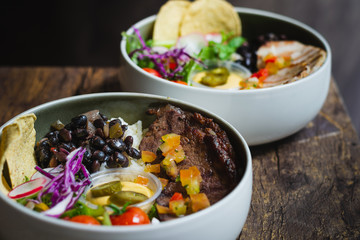Protein Bowl of grilled Striploin, pilaf rice, beans, guacamole, homemade spiced cheese sauce, jalapenos & corn chips