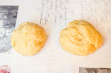 A ball of sweet pastry for shortcake lies on a table sprinkled with flour. Homemade baking. Selective focus.