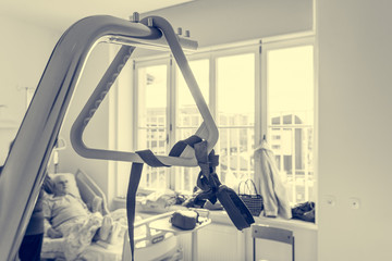 Hospital bed triangle with unrecognizable elderly couple in the background.