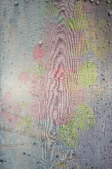 Abstract texture, distorted drawing on thin color translucent fabric, blurred through wet glass.