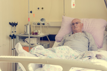 Obraz na płótnie Canvas Elderly man laying on a bed in hospital.