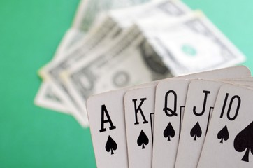 Old playing cards and money on a green background