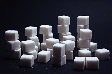 Pile or chart of sugar cubes on a black background.