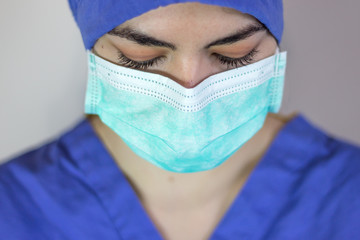 Almost frontal view of female doctor with mask and cap to visit patient with coronavirus.