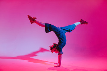 Young stylish girl dancing in the Studio on a colored neon background. Music dj poster design.