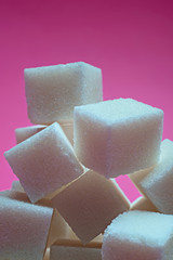 Sugar cubes on a bright pink background. Macro photo.