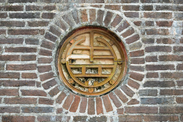 Decorated porthole on a brick wall in the Tomb of Tu Duc. Hue, Vietnam