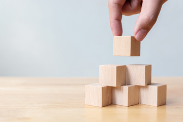 Hand arranging wood block stacking as step stair. Business concept for growth success process