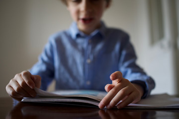 Young primary school age boy being home schooled, having fun while learning