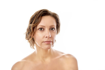 Beautiful young woman looking at the camera with a clean face naked to shoulder posing. isolated white background.