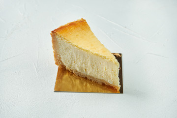 A classic slice of mascarpone cheesecake New York on a white textural background. Close up