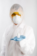 Doctor in anti-epidemic suit holds bottle with pills