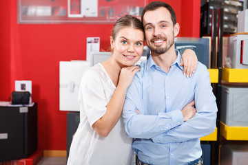 Young loving couple standing in specialty workshop of safes