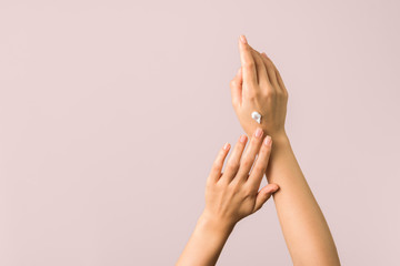 closeup of tender hands of a young woman with moisturizer on. spring skin protection