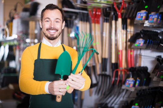 Male Seller Showing Assortment In Garden Equipment Shop