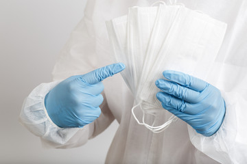 Fototapeta premium Doctor's hand with some medical face mask for protection against infection