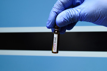 Corona virus or Covid-19 in Botswana , sample blood tube in hand with Botswana flag on background