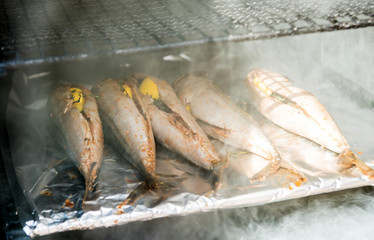Large barbecue smoker grill at the park. Meat prepared in barbecue smoker.