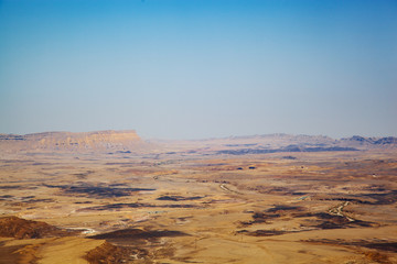 A rocky desert on the horizon. The air is filled with light and ultraviolet haze. View sun-tormented earth. The absence of people where there is no water.