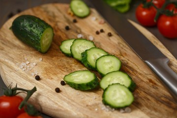Fresh green cucumber sliced ​​on a wooden board