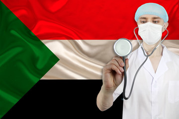 male doctor with a stethoscope on the background of the Sudan silk national flag, concept of national medical care, health, insurance, tourism