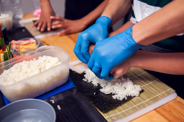 Children making sushi at the master class. Children, education and entertainment.