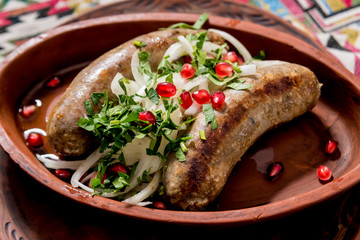 Grilled sausage in a clay pot. Georgian restaurant.