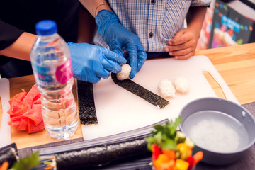 Children making sushi at the master class. Children, education and entertainment.