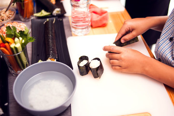 Children making sushi at the master class. Children, education and entertainment.