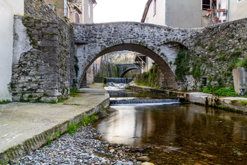 Fototapeta premium Rivière traversant le petit village de mineurs de Saint-Laurent-le-Minier (Occitanie, France)