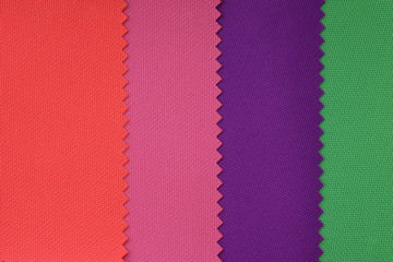 Lightweight fabric made of synthetic fibres (nylon or polyester) of a certain structure with a special coating. Samples of fabrics in pastel colors. red pink green piece of fabric with texture.