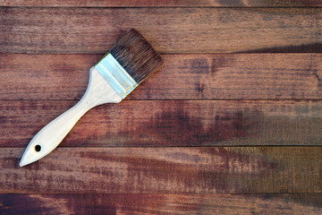 Wooden boards covered with stain top view. A brush with a wooden handle and natural bristles...