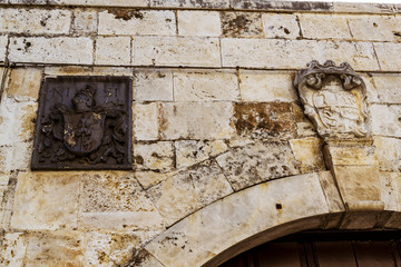 Detalle de arco en piedra y escudo metalico
