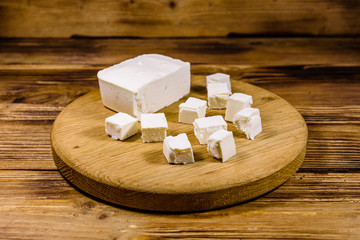 Cutting board with chopped feta cheese on a wooden table