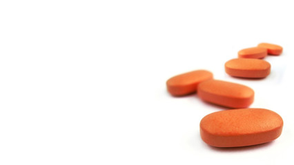 Orange pills isolated on white background